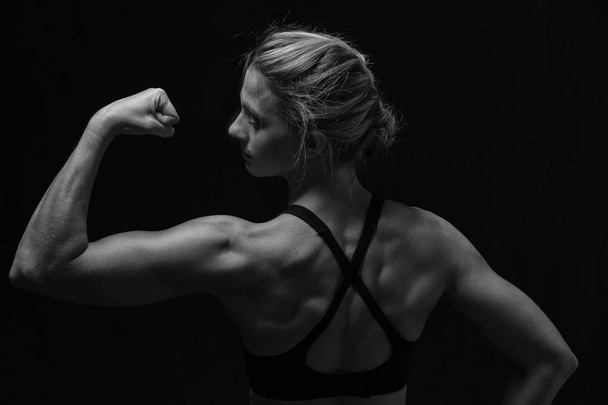 Fit woman with shaped muscles on her back in artistic conversion - Photo, Image