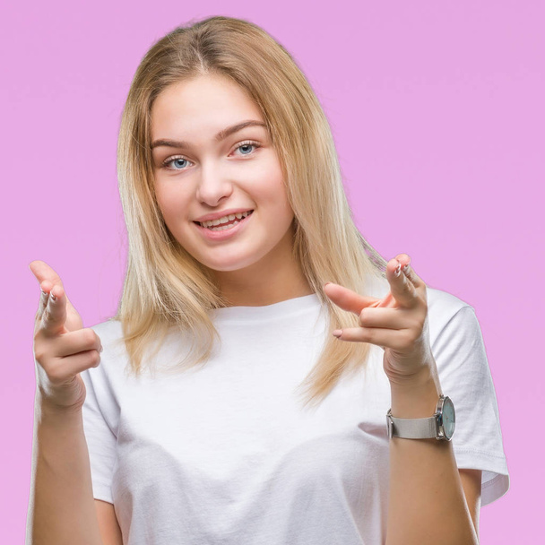 Young caucasian woman over isolated background pointing fingers to camera with happy and funny face. Good energy and vibes. - 写真・画像