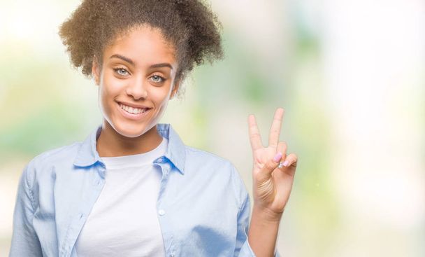 孤立した背景表示と指で上向きに若いアフロ ・ アメリカ人女性数は自信を持って、幸せな笑みを浮かべている間 2. - 写真・画像