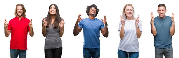 Composition of african american, hispanic and caucasian group of people over isolated white background smiling crossing fingers with hope and eyes closed. Luck and superstitious concept. - Photo, Image