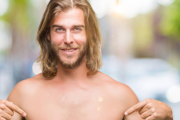 Young handsome shirtless man with long hair showing sexy body over isolated background looking confident with smile on face, pointing oneself with fingers proud and happy. - Photo, Image