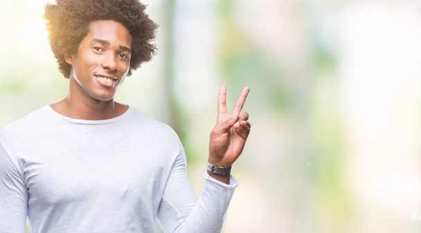 Afro american man over isolated background smiling with happy face winking at the camera doing victory sign. Number two. - Fotografie, Obrázek