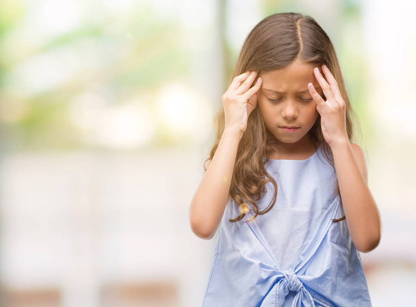 Brünettes hispanisches Mädchen mit der Hand auf dem Kopf für Kopfschmerzen wegen Stress. Migräne. - Foto, Bild