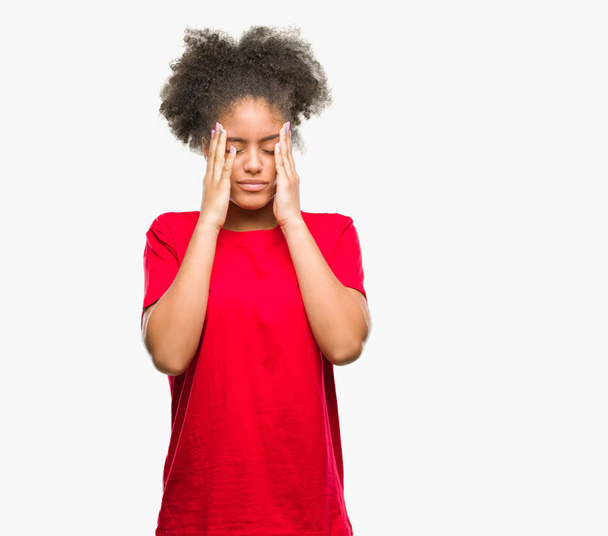 Nuori afroamerikkalainen nainen eristetyn taustan yläpuolella käsi pään päällä kivun vuoksi, koska stressi. Migreeni
. - Valokuva, kuva
