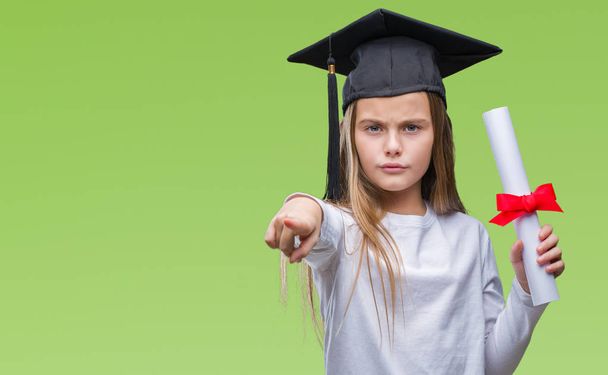 Молодая красивая девушка в дипломной шапке держа степень на изолированном фоне указывая пальцем на камеру и на вас, знак руки, позитивный и уверенный жест спереди
 - Фото, изображение
