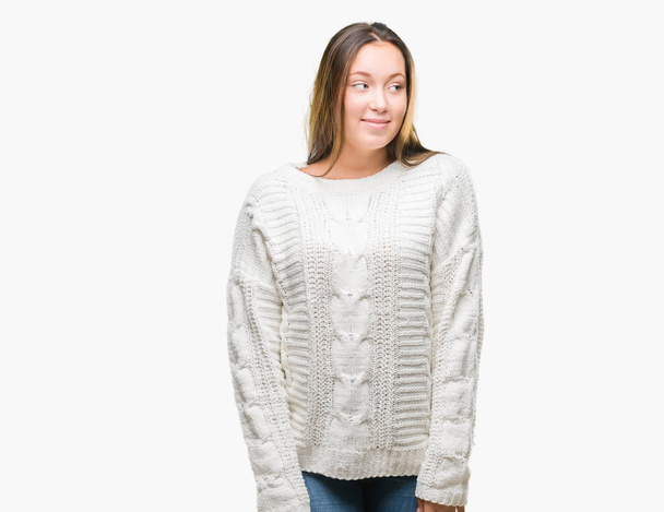笑って見ている側と見つめて離れて思考孤立の背景に冬のセーターを着ている若い美しい白人女性. - 写真・画像