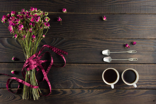 Bouquet of dry flowers with a ribbon on the dark wooden surface - Foto, Bild