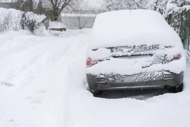 車は白い雪で覆われています。前面のフロント ガラスとボンネットを見る冬の日で覆われている車の雪を凍結、. - 写真・画像