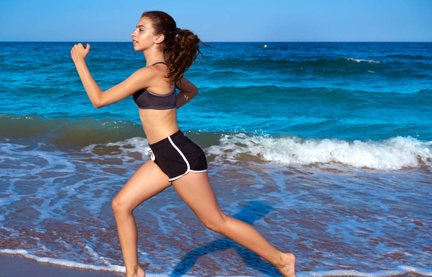Teen runner girl running in beach shore in summer - Фото, изображение
