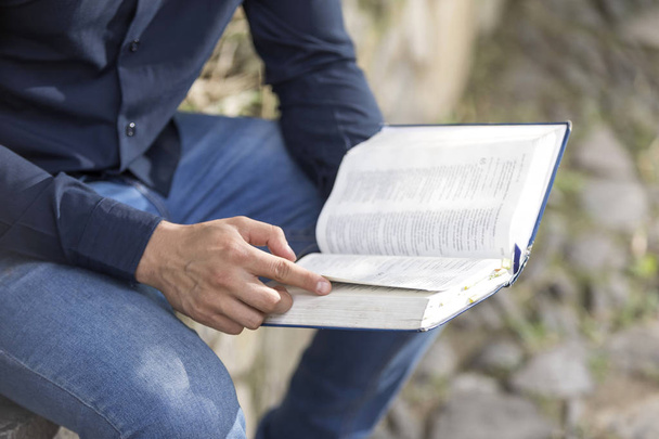 屋外の庭で神聖な聖書を読む青年実業家 - 写真・画像