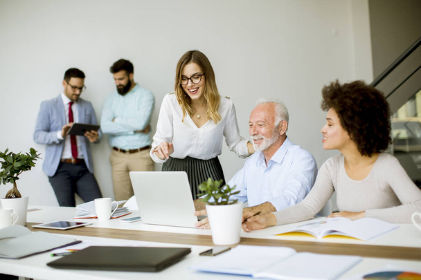 Bekijken van mensen uit het bedrijfsleven een strategie te bespreken en samen te werken in het moderne kantoor - Foto, afbeelding