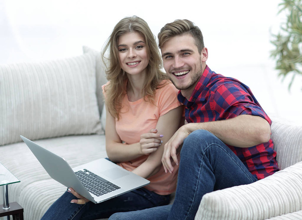 pair students with a laptop sitting on sofa - Φωτογραφία, εικόνα