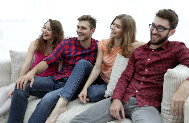 ομάδα χαμογελώντας νέοι άνθρωποι καθισμένοι στον καναπέ - Φωτογραφία, εικόνα