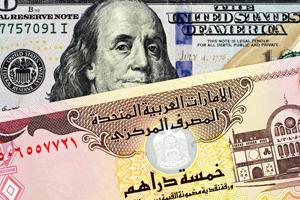 Nahaufnahme eines blauen amerikanischen Hundert-Dollar-Scheins mit einem 5-Dirham-Schein der Vereinigten Arabischen Emirate - Foto, Bild