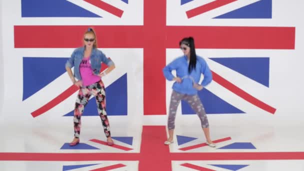 Zkouška ze dvou dívek se slunečními brýlemi na pozadí textury vlajka Velké Británie. - Záběry, video