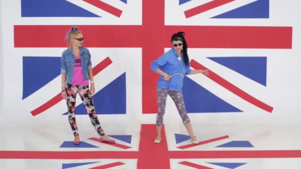Kamera ukazuje zkouška dívek s brýle tančí na pozadí vlajky Velké Británie - Záběry, video