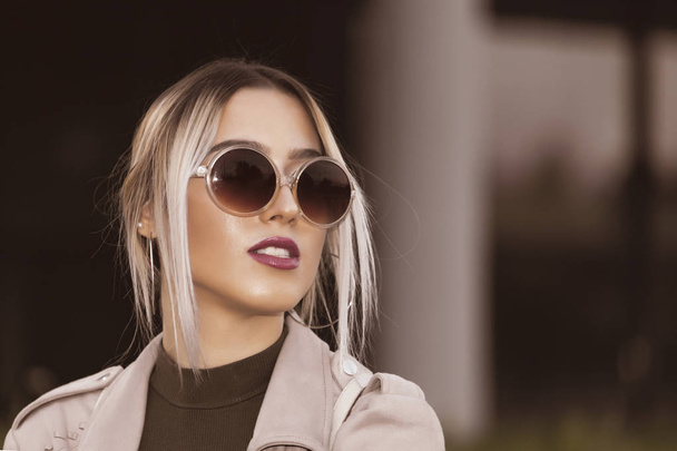 Portrait of a beautiful young modern and urban woman outside with sunglasses - Foto, Imagem