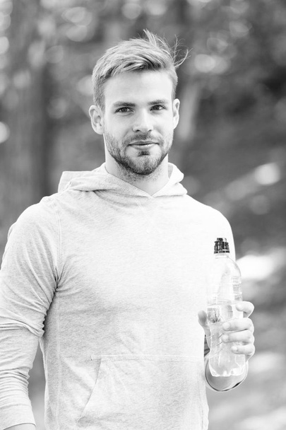 Drink some water. Man handsome jogger holds water bottle whole workout in park. Man athlete sport clothes refreshing. Sport and healthy lifestyle concept. Athlete drink water after training in park - Φωτογραφία, εικόνα