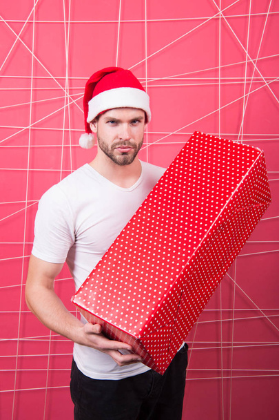 Christmas holiday celebration. Man handsome unshaven santa hat hold gift box. Christmas gift concept. Santa bring gift for you. Man attractive santa claus carry big box. Ready to unpack your gift - Fotó, kép