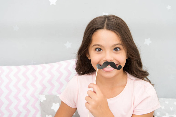 Slumber party photo booth props. Kid girl cheerful posing with black mustache party attribute. Prepare photo booth props hand made or buy for party. Printable photo booth props pajama party - Foto, Imagem
