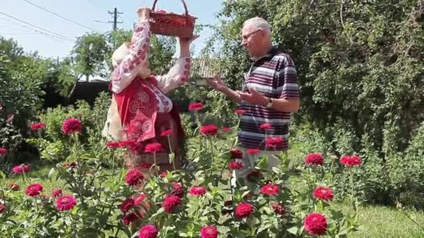 ルーマニア語のカップルには、庭で元気に話している人が引退しました。彼女は新鮮な野菜の入ったかごを保っています。.  - 映像、動画
