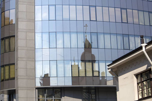 Zniekształcone odbicie stara katedra prawosławna w oknach nowoczesne miasto budynek - Zdjęcie, obraz