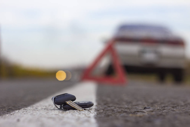 lost car keys lying on the roadway, on a blurred background with bokeh effect - Foto, imagen