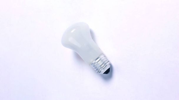 finger touching the bulb. isolated on a white background. photo with copy space - Photo, Image