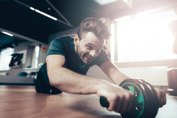 Sporty Man Is Doing Exercises With The Gym Wheel. Active Lifestyle. Sweat Body. Holiday Leisure. Fitness Day. Repeat Press Exercise. Active Lifestyle. Getting Better. Gym Equipment. - Photo, image