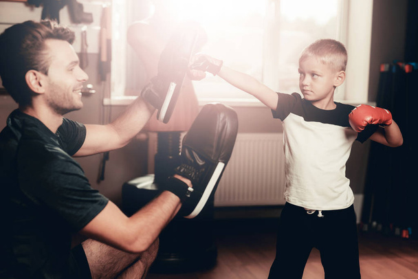 Father And Son Boxing Exercises Training In Gym. Parenthood Relationship. Sporty Family Concept. Active Lifestyle. Kid In Boxing Gloves. Holiday Leisure. Working Out Together. Fitness Day. - Foto, Imagen