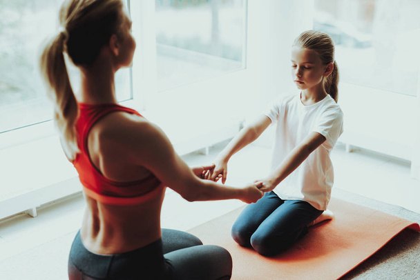 Mother And Daughter Sitting On Gym Carpet. Yoga Concept. Meditation Pose. Active Lifestyle. Hold Each Other Hands. Fitness At Home. Holiday Leisure. Body Balance. Sport Exercise. Sunny Morning. - Foto, Bild