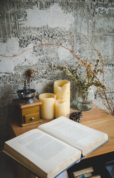 open book, coffee grinder on wooden table, focus on candles - Photo, Image