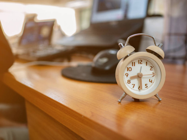 Fechar pequeno relógio de alarme na mesa de trabalho no escritório, Conceito hora de wor
 - Foto, Imagem