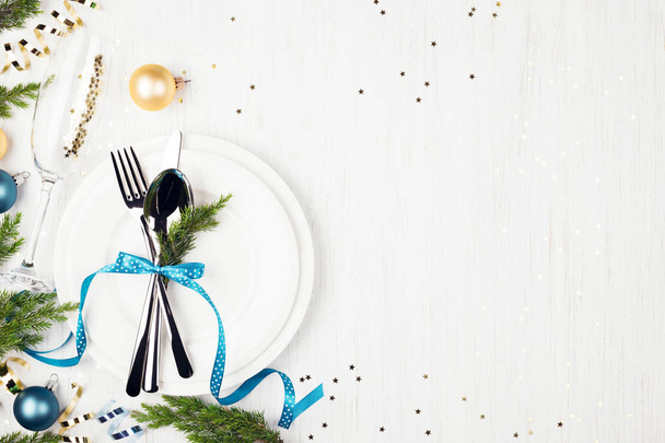 Christmas table setting with blue and golden decorations and evergreens. - Foto, Bild