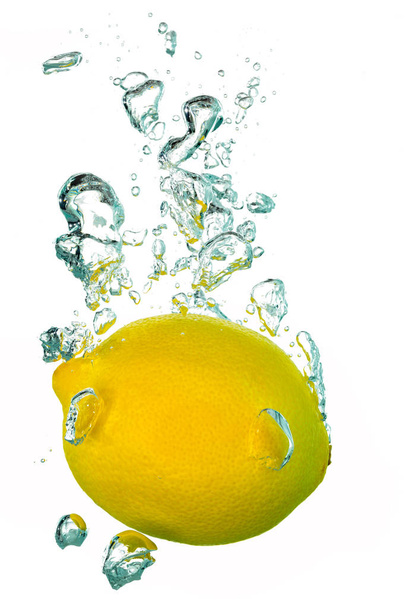 A single lemon splashing into water with air bubbles - Photo, Image