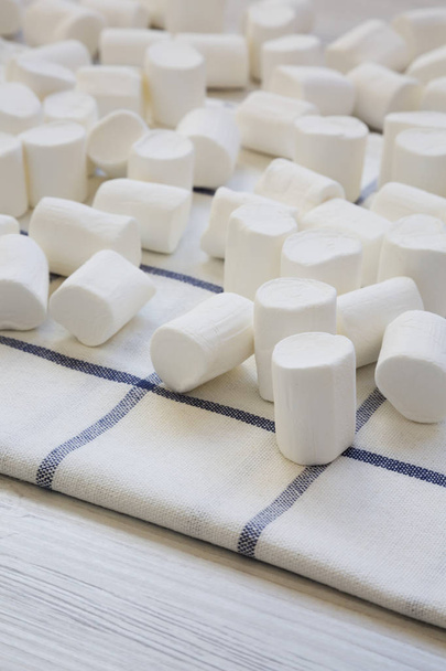 Zoete witte marshmallows op doek, zijaanzicht. Close-up. - Foto, afbeelding