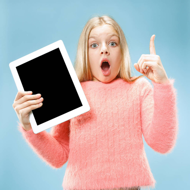 Little funny girl with tablet on blue background - Foto, Imagen