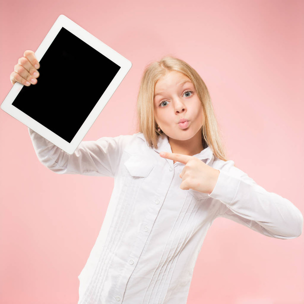 Little funny girl with tablet on pink background - Фото, зображення
