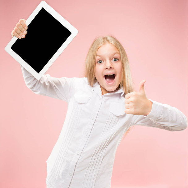 Little funny girl with tablet on pink background - Photo, image