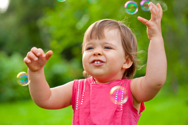 Маленька дівчинка в парку з бульбашками
 - Фото, зображення