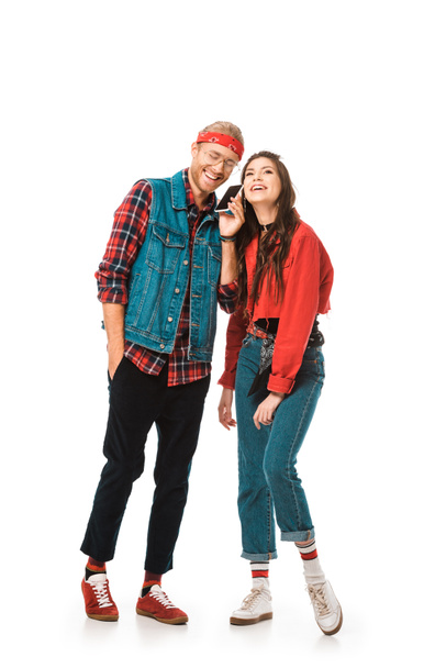 happy young hipster talking on smartphone while his girlfriend standing near isolated on white - Photo, Image