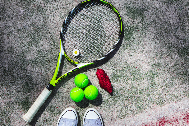 France, Paris - 15 August 2018: Tennis racket Head and balls, player feet, autumn leaf. - Zdjęcie, obraz
