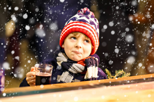Μικρό παιδί αγόρι πίνοντας ζεστή σοκολάτα στην Χριστουγεννιάτικη αγορά - Φωτογραφία, εικόνα