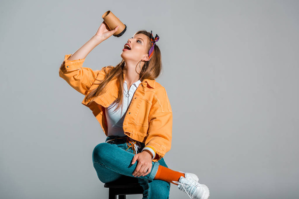 attractive stylish girl drinking coffee to go isolated on grey - Photo, Image