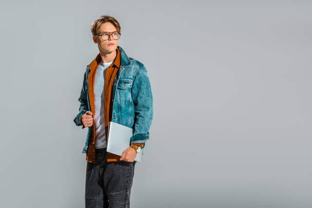 beau hipster masculin élégant posant avec ordinateur portable isolé sur gris
 - Photo, image