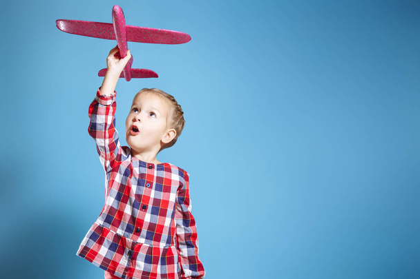 Happy child girl playing with toy airplane. The dream of becoming a pilot - Foto, Bild