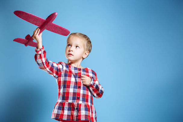 Happy child girl playing with toy airplane. The dream of becoming a pilot - Foto, Imagem