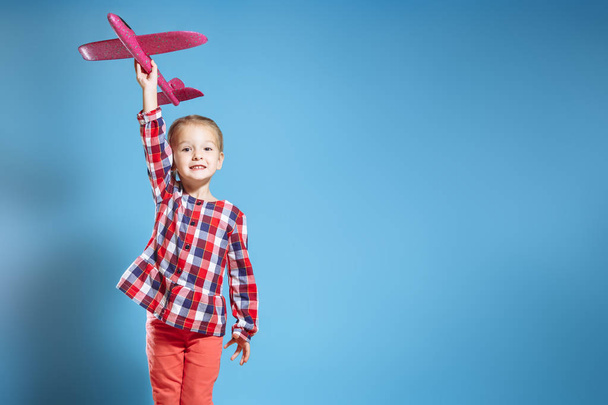 Happy child girl. Little girl playing with toy airplane. - Foto, Imagen