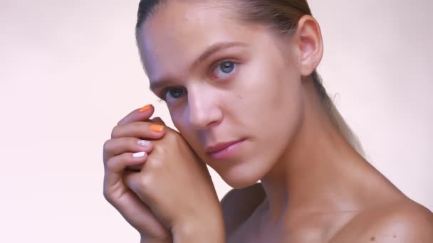 Perfect close-up skin and face of caucasian girl, looking at camera relaxed in white studio - Imágenes, Vídeo