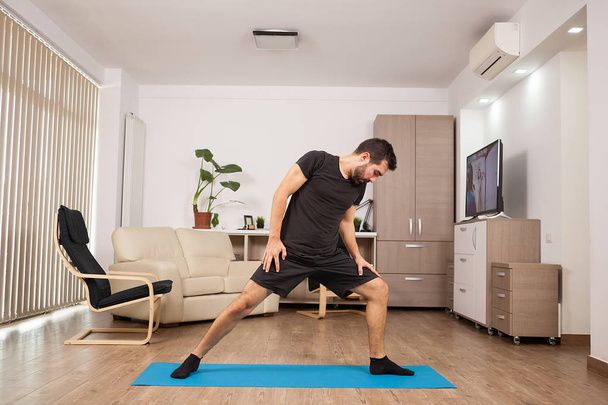 bärtiger Mann, der Krieger-Yoga macht und seine Muskeln dehnt - Foto, Bild